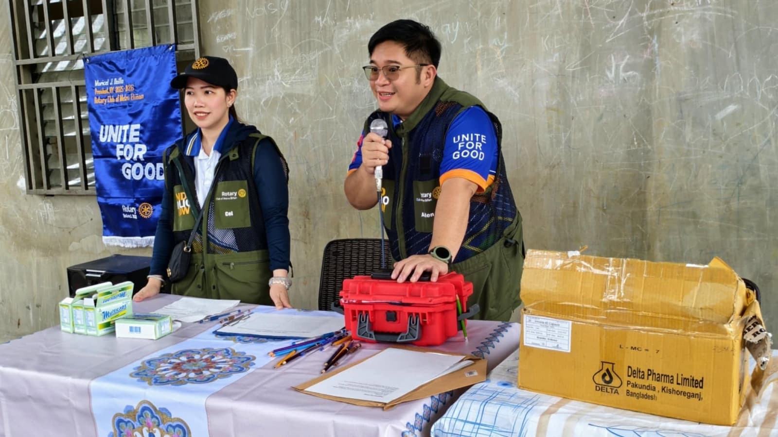 A Rotary Club of Metro Biñan member speaking with the community