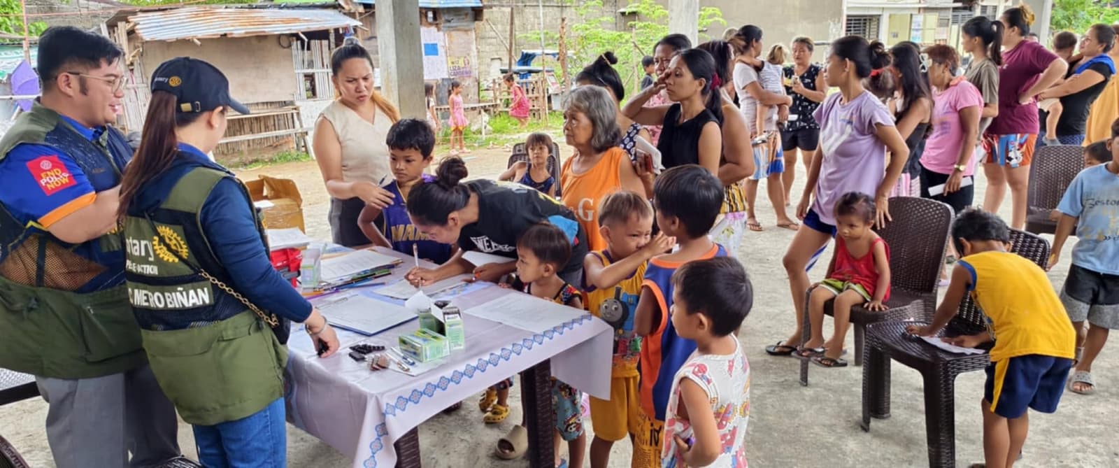 Members of the Rotary Club of Metro Biñan assisting families at a community outreach